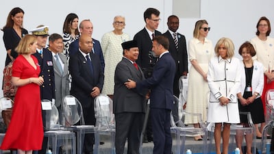 Mr Macron shakes hands with Indonesia's President Prabowo Subianto as the parade reaches Place de la Concorde. Reuters