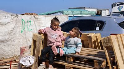 Displaced children sit on wooden pallets, as displaced Palestinians take shelter in a tent camp near the border with Egypt in Rafah. Reuters