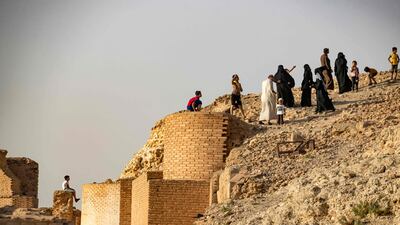 People climb the ruins of Jaabar Citadel.