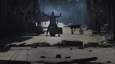A masked Kashmiri Muslim taunts Indian police during a protest after the funeral of Riyaz Ahmad Shah, a civilian killed by government forces in Srinagar. Dar Yasin / AP Photo