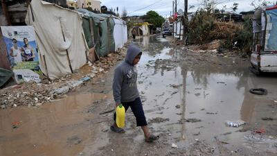 A young Syrian refugee walksthrough a muddy alley at a makeshift camp in the village of Kfarkahel, in the Kura district near the northern city of Tripoli. Ibrahim Chalhoub / AFP Photo