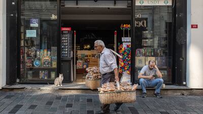 A street vendor passes a book store in Istanbul, Turkey. Recent indicators point to a continued increase in the underlying trend of inflation, the central bank said. Bloomberg