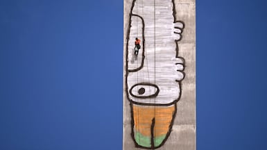 Abseilers prepare to paint over Pam the Bird graffiti, spray-painted on a 140-metre-tall pylon by alleged vandal Jack Gibson-Burrell, on Melbourne's Bolte Bridge. AFP