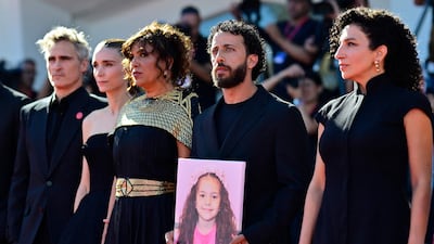 US actor Joaquin Phoenix, US actress Rooney Mara, Tunisian director Kaouther Ben Hania, actor Motaz Malhees and actress Clara Khoury pose with a portrait of late Palestinian girl Hind Rajab during the red carpet for The Voice of Hind Rajab, which has been submitted to the 2026 Oscars. AFP