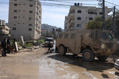 Israeli army vehicles drive down a road amid a weeks-long offensive at the Jenin refugee camp in the occupied West Bank on February 25, 2025. (Photo by Jaafar ASHTIYEH / AFP)