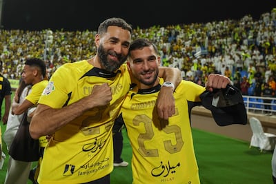 Houssem Aouar, right, celebrates Al Ittihad's title success with captain Karim Benzema. Getty Images