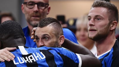 Inter Milan's Croatian defender Marcelo Brozovic celebrates with Inter Milan's Belgian forward Romelu Lukaku after his deflected free kick saw Inter take the lead against AC Milan at San Siro. Inter went on to win the match 2-0. AFP