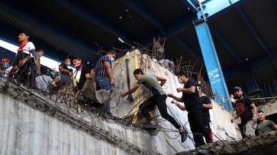 Iraqi demonstrators climb inside the high-rise Turkish Restaurant Building. Reuters
