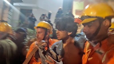 Rescue workers with a man after he was pulled from the debris of the collapsed building. Reuters