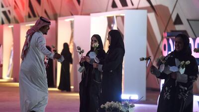 Saudi women distribute flowers to incoming attendees. Fayez Nureldine / AFP