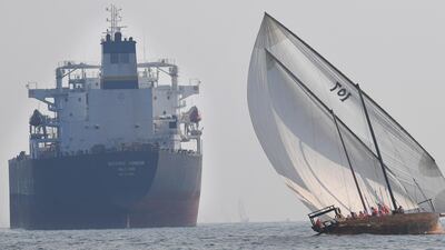Emirati competitors sail their dhow past a crude oil tanker Navig8 Honor during the Dalma Sailing Festival. AFP