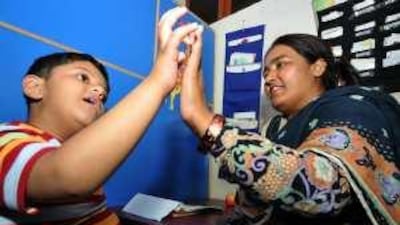 Bilal Kiyani, six, with a teacher at the Step To Learn School for special-needs children in Islamabad. Pakistani children born with neurological disorders like autism have little prospect of a functional adult life because of social ignorance and an absence of trained professionals.