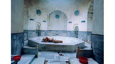 Relaxing on the hot göbektasi, an hexagonal podium encircled with arched side chambers in the Cinili Hammam.