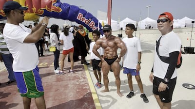 A bodybuilder poses with visitors at the asthma awareness walkathon in Dubai on Friday. Jaime Puebla / The National