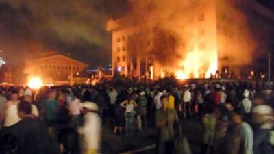 Protesters from the rival Democratic Party gather outside the headquarters of the former communist Mongolian People's Revolutionary Party, which was set alight and looted, during a violent protest in Ulan Bator on July 1, 2008.