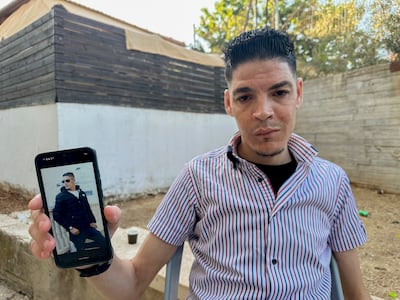 Mohammad Imad Khallaf, who says he suffered severe abuse in Israeli prisons, shows an older photo of himself. AFP