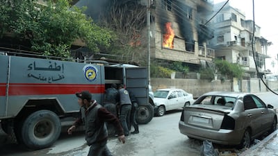 Syrian firefighters use a hose to extinguish fire following Syrian government shelling on the town of Douma in the rebel-held enclave of Eastern Ghouta on the eastern outskirts of the capital Damascus on March 10, 2018. Hamza Al-Ajweh / AFP