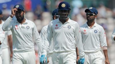 India’s wicketkeeper captain MS Dhoni, centre,leads his team off for lunch on the fourth day of the third cricket Test match between England and India at The Ageas Bowl cricket ground in Southampton on July 30, 2014. AFP PHOTO / OLLY GREENWOOD