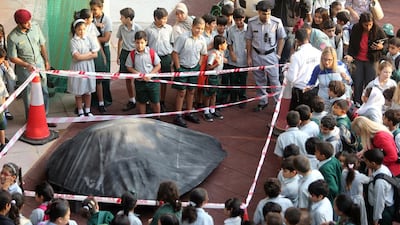 Children at Al Mushrif Primary School inspect a suspected UFO that landed at the school. Sammy Dallal / The National