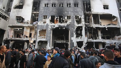 Gazans gather outside the damaged hospital. The Israeli raid began in the early hours of the morning on 18 March. AFP