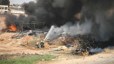 Firefighters work at the site of the explosion in the town of Samarda in Syria's Idlib province. AFP