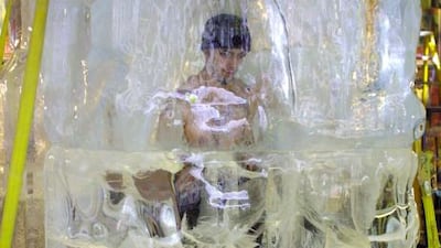 US magician David Blaine is surrounded by a block of ice in Times Square in New York, 27 November 2000. Blaine is attempting to freeze himself in the six-ton block of ice for 58 hours. AFP PHOTO/Doug KANTER