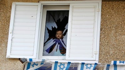 A baby is seen at a broken window after a rocket fired by Palestinian militants in Gaza hit a house in the southern town of Netivot. Amir Cohen / Reuters