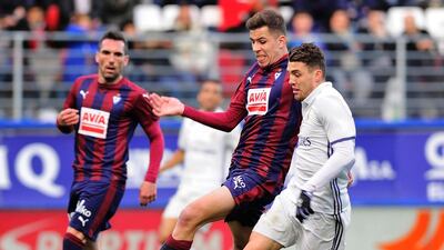 Eibar’s Christian Rivera, centre, vies with Real Madrid’s Croatian midfielder Mateo Kovacic. Ander Gillena / AFP