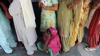 An Indian voter rests in the queue prior to casting her ballot at a polling station near Attari village, about 35 kms from Amritsar. Narinder Nanu / AFP