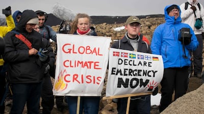 People hold up signs as a monument was unveiled at the site of Okjokull, Iceland's first glacier lost to climate change in the west of Iceland. AFP