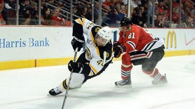 Dennis Seidenber, No 44, of the Boston Bruins, skates after the puck ahead of Marian Hossa of the Chicago Blackhawks in Game 2. Harry How / Getty Images / AFP