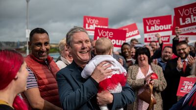 Labour party leader Keir Starmer holds a baby in Medway, where his party won the local election. Getty