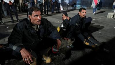 Firefighters rest on the ground after extinguishing the blaze. Reuters