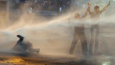 Supporters of opposition leader Leopoldo Lopez are hit by police water canon on February 19, 2014, during a protest against Nicolas Maduro’s government in Caracas. Tensions have risen in Venezuela since Lopez, a 42-year-old Harvard-educated economist, surrendered to troops on Tuesday after spearheading three weeks of demonstrations against president Maduro’s government. Carlos Garcia Rawlins / Reuters