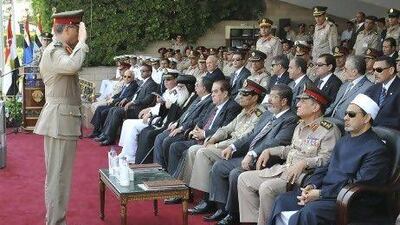An Egyptian military officer salutes president Mohammed Morsi, third from right, at a military graduation ceremony in Cairo. Morsi is now on a collision course with the Egyptian military after ordering the parliament to reconvene.