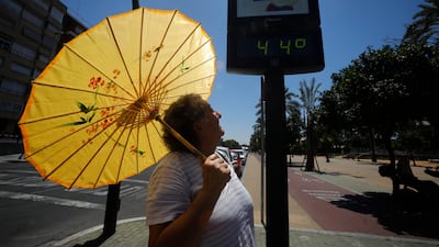 A tourist with an umbrella protects herself from the heat in Cordoba, southern Spain, during a hot day in the south of the country. EPA