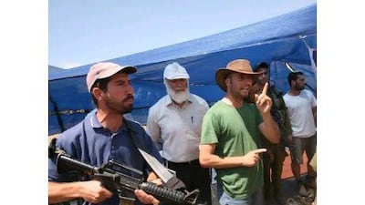 Israeli soldiers (R) hold back armed Israeli settlers (L) who are confronting Palestinian protesters (unseen) near tents set up by settlers in Palestinian land in the occupied West Bank near the village of Tubas, south-east of Jenin, on April 28, 2010. Palestinian president Mahmoud Abbas has said he hopes for a "positive response" when he presents US proposals for renewed negotiations with Israel to Arab foreign ministers next week.