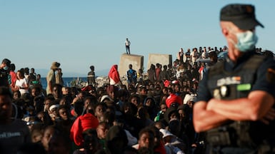 Migrants wait in line to receive food and beverage from the Red Cross, following mass crossings of migrants on foot and by sea from Morocco into Spanish territory, in Ceuta, Spain, August 3, 2026. REUTERS / Violeta Santos Moura TPX IMAGES OF THE DAY