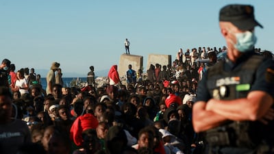 Migrants wait for food in the Spanish territory of Ceuta after surging across the border from Morocco. Reuters