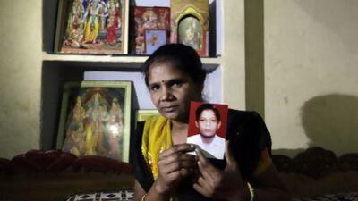 Pravesh Kumari Singh, 36, shows a photo of her son, Pankaj, 14, who went missing in 2010, from her house in New Delhi. More than 90,000 children go missing in India each year.