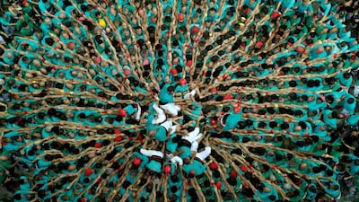 Members of group 'Castellers de Vilafranca' fold down after forming a human tower called 'castell' during a biannual human tower competition in Tarragona, Spain. Reuters