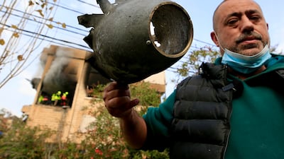 A man holds missile debris in Haret Saida. EPA