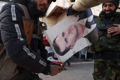 Rebel fighters set fire to a picture of Syrian President Bashar Al Assad in an area seized by insurgents in Zarbah, northern Syria. AFP