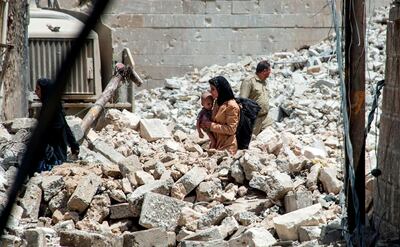 An Iraqi woman and child walk through the rubble of the Old City of Mosul, on July 2, 2017. AFP