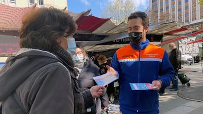 Volunteers from French Protection Civile association hand out leaflets at a market to try to persuade Parisians over 55 to have the AstraZeneca vaccine, in Paris, France. Reuters