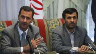 The Syrian president Bashar Assad, left, with his Iranian counterpart Mahmoud Ahmadinejad, in Tehran today. A senior military aide to Mr Assad was found shot dead in a hotel room on Friday.