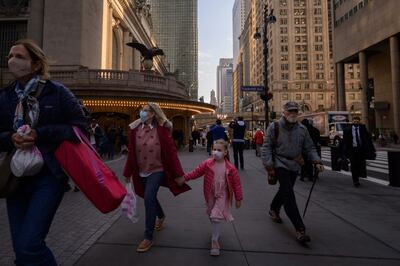 A family wearing face masks walk on a street in New York on December 6. AFP