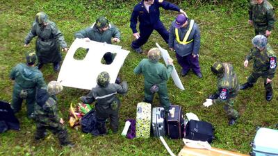 Soldiers recover plane wreckage and passengers’ luggage. David Chang / EPA