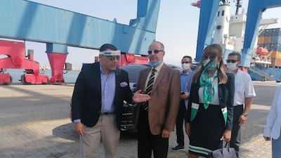 Egyptian Ambassador Yasser Elwi, left, chats with Dany Gedeon, director general of Lebanon's industry ministry, centre, as they wait with other officials to receive a shipment of glass from Egypt at Beirut port on August 28, 2020. Sunniva Rose for The National