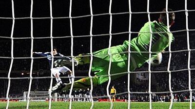 Uruguayan goalkeeper Fernando Muslera saves the shot by Carlos Tevez in the quarter-final in Santa Fe.